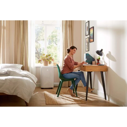 Qlima portable air conditioner cooling a home office/bedroom workspace.