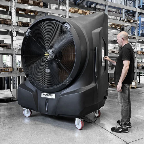 Master BC451 commercial evaporative air cooler shown in a warehouse beside an operator for size comparison